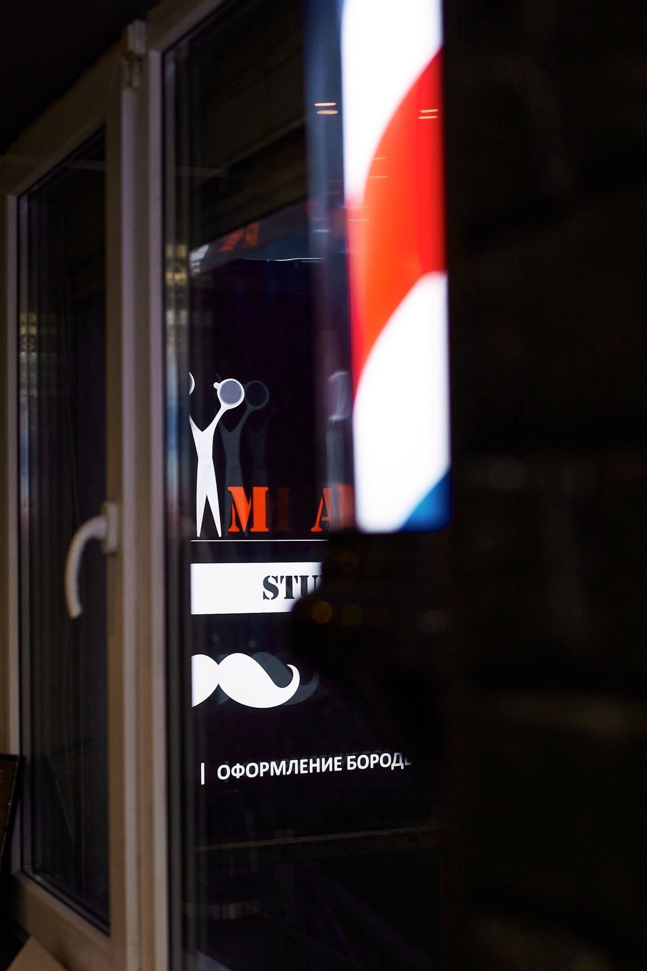 Входная дверь с логотипом ALIMAN и надписью BARBER STUDIO